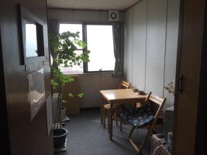 a dining room with a table and chairs and a window at Mimatsuso Ryokan in Asahikawa