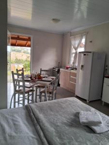 a kitchen with a table and a white refrigerator at Villa Holística in Nova Petrópolis