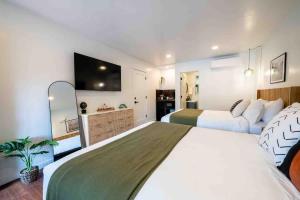 a large bedroom with two beds and a flat screen tv at Columbia Cabins Cabin 7 in Sonora