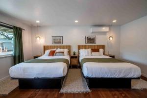 two beds in a bedroom with a window at Columbia Cabins Cabin 8 in Sonora