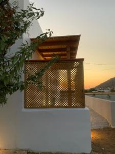 a metal pergola on a white wall with the sunset in the background at Villa NanSea in Kastraki