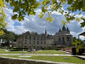 people walking in front of a large building at Les Gites de Durbuy in Septon