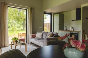een woonkamer met een bank en een tafel bij Gastenverblijf Beekweide - de Notenboom in Voorst