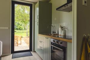 een keuken met een spoelbak en een fornuis bij Gastenverblijf Beekweide - de Notenboom in Voorst