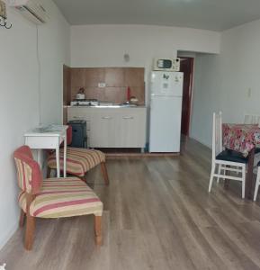 Una cocina con mesa y sillas y un refrigerador. en Mi Departamentito, en Federación