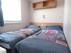 two beds sitting next to each other in a bedroom at En bord d'eau - charmant Mobil-home climatisé - Cap ferret in Lège-Cap-Ferret