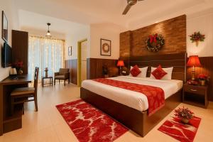 una camera d'albergo con un letto grande e una scrivania di The Ruby Resort, Vrindavan #prime location #luxury rooms #near prem mandir #restaurant #big lawn #parking a Vrindāvan Altre 24 foto