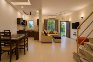 un soggiorno e una cucina con un tavolo e un divano di The Ruby Resort, Vrindavan #prime location #luxury rooms #near prem mandir #restaurant #big lawn #parking a Vrindāvan