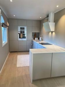 a kitchen with white cabinets and a counter top at Modern 3 bedroom villa 10min from Oslo Airport Gardermoen in Jessheim