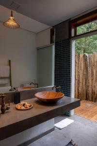 a bathroom with a wooden bowl sink on a counter at Casa Marlim - Trancoso Eco Residence in Porto Seguro