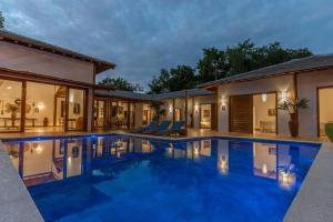 a large swimming pool in front of a house at Casa Marlim - Trancoso Eco Residence in Porto Seguro