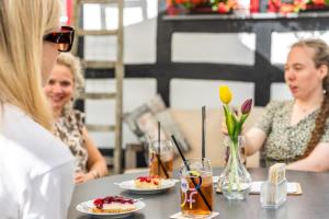 Una donna seduta a un tavolo con piatti di cibo di Garni Hotel im Fachwerkhof a Simmerath Altre 25 foto
