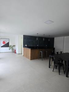 a room with a table and chairs and a kitchen at Home Easy Flat in Volta Redonda +12 photos