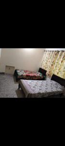 a room with two beds and a curtain at Al Muqtadir girls hostel in Islamabad