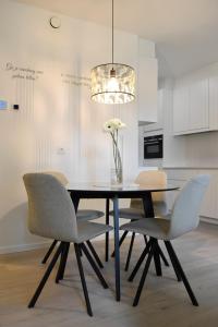 a dining room table with chairs and a vase of flowers at Bartine - modern and spacious flat near the sea, free parking space in Ostend