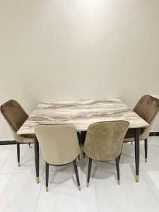 een tafel en stoelen met een marmeren tafel en stoelen bij Boulevard Apartment-H1 in Riyad