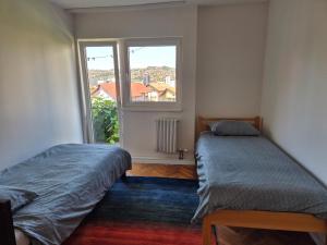 a bedroom with two beds and a window at Golden View Apartment in Sarajevo