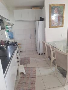 a kitchen with a refrigerator and a table and chairs at Chácara Jatoba in Belém