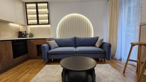 a living room with a blue couch and a table at Sila apartman Vrnjačka Banja in Vrnjačka Banja