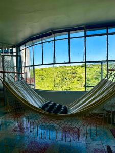 a hammock in a room with a large window at Silencio y naturaleza en Cuernavaca in Cuernavaca