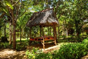 ディアニ・ビーチにあるAfrican Huts Villasの草の屋根が付いた森の中の天蓋付きベッド