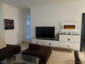 a living room with a flat screen tv on a dresser at Donovaly Triangel A10 in Mistríky