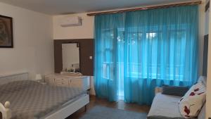 Un dormitorio con una cama y una cortina azul. en Apartman Nona, en Rijeka