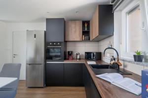 a kitchen with black cabinets and a stainless steel refrigerator at Vita Laboris in Valtura