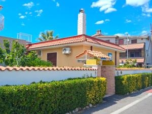 a yellow house with a chimney and a fence at A casa dell' Artista in Fiumicino