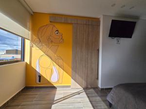 a room with a painting of a woman on the wall at Estainn Hotel Coworking in Bogotá