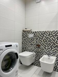 a bathroom with a washing machine and a toilet at Apartament Sara in Oleśnica +14 photos