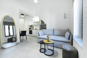 a living room with a blue couch and a mirror at DS Elegant Apartment in Ermoupoli