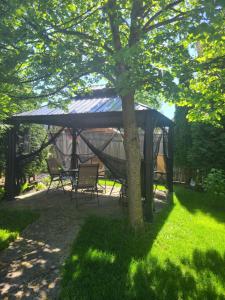 a gazebo with a table and chairs under a tree at Maya Bed and Breakfast in Port Perry