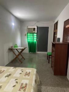 a room with a bed and a door with a green curtain at Abuela Clara 
