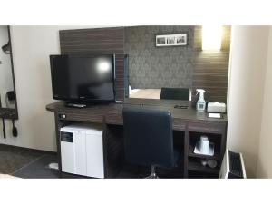 a desk with a television and a bed in a room at Smile Hotel Kokura - Vacation STAY 67795v in Kitakyushu +7 photos