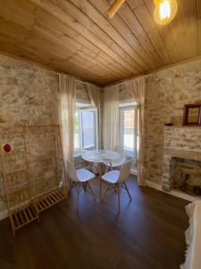 a room with a table and chairs and a fireplace at Papu's Villa in Piqeras