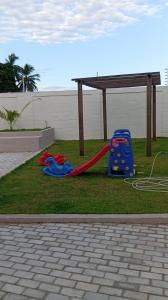a playground with a slide on the grass at Casa duplex em Parnaíba - casa73phb in Parnaíba