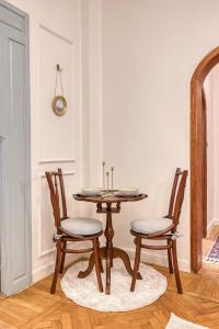 - une salle à manger avec une table en bois et 2 chaises dans l'établissement 2BD DownTowen Khan Al-Andalus, au Caire