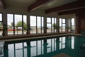 a large swimming pool in a building with windows at Departamentos Natales in Puerto Natales