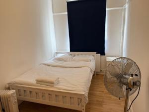 ロンドンにあるRahal Hotel Hackney Londonの小さなベッドルーム(ベッド1台、ファン付)