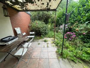 Un patio al aire libre con una mesa y sillas de madera. en CITY HAUS für 8 Personen, en Bremen