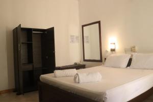 a bedroom with a large white bed with a mirror at Elephant vale in Kegalle