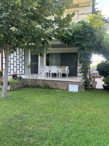 a house with a table and chairs on the porch at Villa Amalia Perla Resort in Draçi