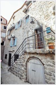 ein Steingebäude mit einer Tür und einem Balkon in der Unterkunft Sailor House in Budva