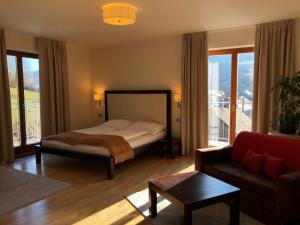 a bedroom with a bed and a living room with a couch at Villa Malina in Oščadnica
