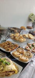 a table with plates of pies and other foods at Pousada Shangrila RP in Ribeirão Preto