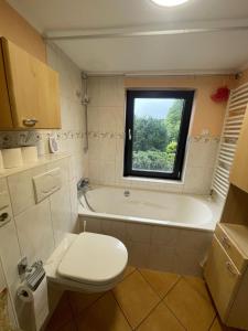 Un baño con bañera, inodoro y ventana. en CITY HAUS für 8 Personen, en Bremen