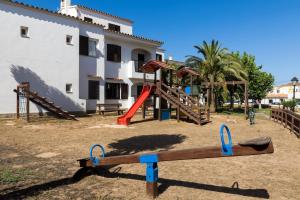 a playground in front of a house with a slide at Binilivin' Menorca CalaPorter in Cala en Porter