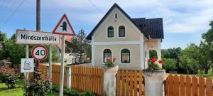 a small house in front of a fence at Káli Panoráma Ház in Mindszentkálla +3 photos