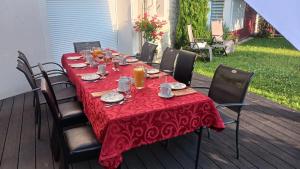 einen Tisch mit einem roten Tischtuch auf einer Terrasse in der Unterkunft les prés de la reine in Saint-Doulchard